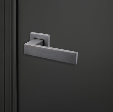 Moderne Lavuzo Imperio deurklink Gun Metal op vierkant rozet op zwarte deur, rechteraanzicht