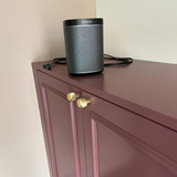 De Gouden ribbel meubelknop toegepast op een bordeaux geschilderde kast met sierlijsten op de deur