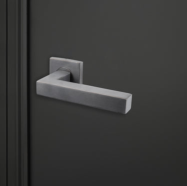 Moderne Lavuzo Viterbo deurklink Gun Metal op vierkant rozet op zwarte deur, rechteraanzicht